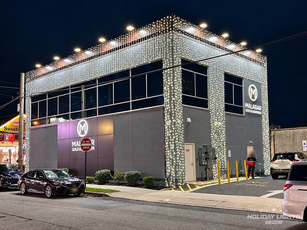 Rear corner of the Iselin store with cool white curtain lights on the upper façade and down the vertical columns
