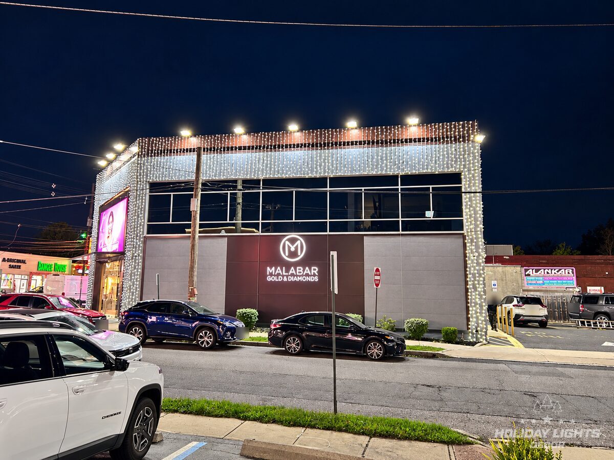 Side elevation of the Iselin jewelry store with cool white curtain lights along the roof edge and down both corners