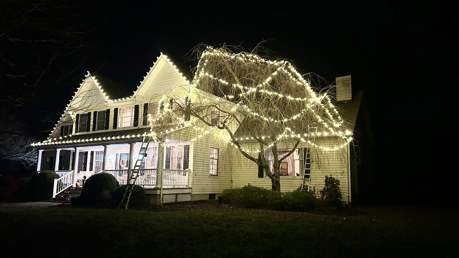 Permanent LED roofline lighting on an upscale home at dusk